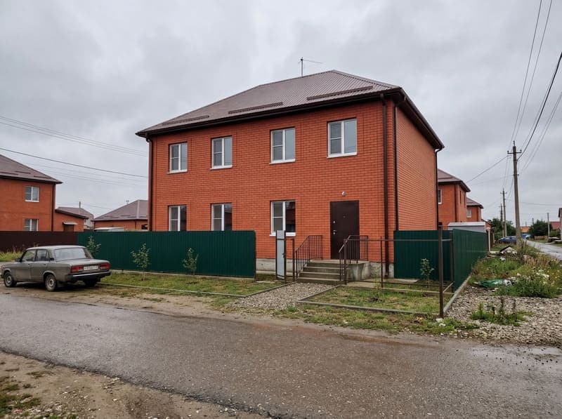 Двухэтажный кирпичный дом-коробка без архитектурного дизайна